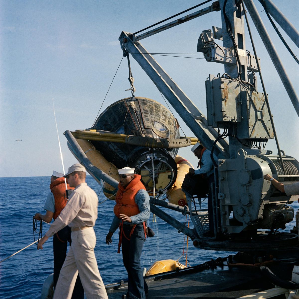 Gemini VIII being lifted aboard a recovery ship with the crew still inside